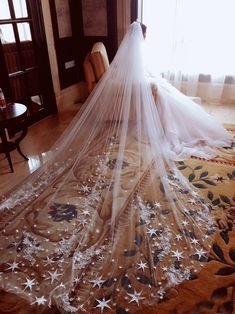 a woman in a wedding dress is sitting on the floor with her veil over her head