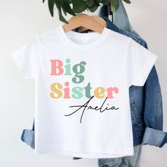 Big Sister T-Shirt, Big Sister Boho T-Shirt, Promoted To Big Sister, Personalised T-shirt, Pregnancy announcement, Going To Be A Big Sister Personalised Big Sister t-shirt T-shirt is 100% Australian cotton.  We design & print our products with care & love! We use the best quality vinyls, inks & transfers on all products. * * * * * * * * * * * * * * * * * * * * * * * * * * * * * CARE INSTRUCTIONS: Wash inside out on gentle wash, Do not tumble dry. * * * * * * * * * * * * * * * * * * * * * * * * * * * * * SHIPPING: We want to get your product to you as quickly as possible, your purchase will be shipped through Australia post, Express post is available for selection. * * * * * * * * * * * * * * * * * * * * * * * * * * * * * GUARANTEE: We stand behind our products with a 100% guarantee; if you Basic Crew Neck T-shirt For Birthday, Cute Multicolor T-shirt With Name Print, White Custom Print Family Matching T-shirt, White Custom Print Family T-shirt, White Short Sleeve T-shirt For Family Matching, Basic White Top For Birthday, White Cotton T-shirt With Name Print, White Basic Top For Birthday, White Birthday T-shirt With Text Print