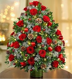 a christmas tree with red roses and pine cones