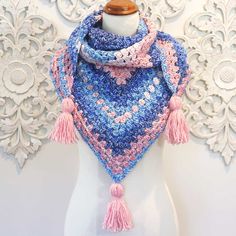 a white mannequin with a blue and pink crochet scarf on it