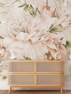 a floral wallpaper with white and pink flowers on the sideboard in front of it