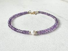 This bracelet features AAA amethyst surrounding a near-perfect freshwater pearl. Amethyst has been said to balance emotions, enhance intuition and decision-making, boost the immune system, and promote deeper sleep. Birthstone: February (amethyst), June (pearl) DETAILS * 6.5 inches + 1.5-inch extender chain (total length: 8 inches) * Natural AAA Purple Amethyst, 3mm faceted rondelles * Natural AAA Freshwater Pearl, roughly 5mm nearly-round * 14K gold-filled components, spring ring clasp * Strung Elegant Purple Birthstone Beaded Bracelets, Purple Amethyst Birthstone Bracelet, Purple Rondelle Beaded Bracelets As Gift, Purple Pearl Bracelet With Round Beads As Gift, Purple Pearl Bracelet With Round Beads For Gift, Gift Purple Pearl Bracelet With Round Beads, Purple Pearl Bracelet Gift, Purple Amethyst Rondelle Bracelets, Purple Rondelle Amethyst Bracelets