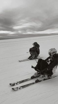 three people on skis sitting in the snow