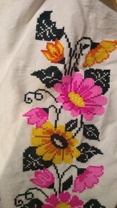 an embroidered piece of cloth with flowers on it