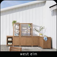 a wooden table sitting next to a white building