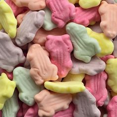 there are many different colored candies in the pile together and one is pink, yellow, green, and blue