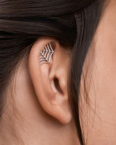 a close up of a person wearing a pair of ear piercings on their ears