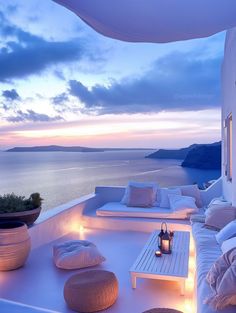 an outdoor seating area overlooking the ocean at dusk