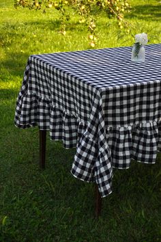 a black and white checkered tablecloth with flowers on it sitting in the grass