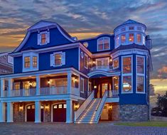 a large blue house sitting on top of a cobblestone road