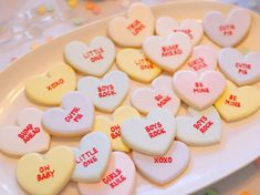 some heart shaped cookies are on a white platter with words that read little ones be mine