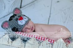 a baby is wearing a crocheted hat with a teddy bear on it