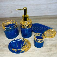 blue and gold bathroom accessories set on wooden table