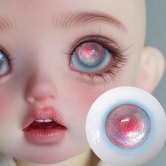 a close up of a doll's face with pink and blue eyes