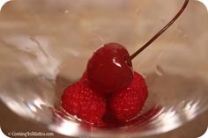 two raspberries in a glass bowl with water