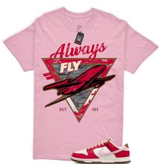 Dunk Bacon Low PRM Sport Red Sheen Sail Medium Brown White Match Shirt "Always Fly" Custom Tees made to match your sneakers! The perfect shirts for matching your shoes with your outfit. This t-shirt is made to go with the Dunk Bacon Low PRM Sport Red. The unisex heavy cotton tee is the basic staple of any wardrobe. It is the foundation upon which casual fashion grows. All it needs is a personalized design to elevate things to profitability. The specially spun fibers provide a smooth surface for Casual Sports Shirt With Graphic Print, Pink Sports Shirt With Graphic Print, Pink Casual T-shirt For Sports, Red Shirt With Front Print For Streetwear, Casual Red T-shirt With Front Print, Casual Pink Sports Shirt, Sporty Pre-shrunk Pink Shirt, Sneaker Match Tees, Matching Jordans