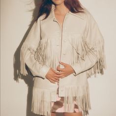 Our Dancassab Loretta Jacket In Moon Grey Features Long Sleeves, Front Button Closures, And Layers Of Fringe Across The Chest, Back, And Sleeves. This Design Is Accented With Two Hand Pockets And An Extra Layer Of Fringe At The Hem. Handcrafted By Artisans In Mexico Using Materials That Are Byproducts Of The Local Food Industry And Are Vegetable-Dyed. Each Piece Takes Up To A Week To Create By Hand. Shell: 100% Sustainably And Ethically Sourced And Vegetable-Dyed Leather Do Not Expose For Long P Chic Beige Outerwear With Fringe, Chic Beige Fringe Outerwear, Chic Fringe Outerwear For Work, Elegant Long Sleeve Outerwear With Fringe, Chic Leather Jacket With Fringe, Chic Leather Jacket With Fringe And Long Sleeves, Chic Long Sleeve Leather Jacket With Fringe, Chic Long-sleeve Leather Jacket With Fringe, Beige Long Sleeve Outerwear With Fringe