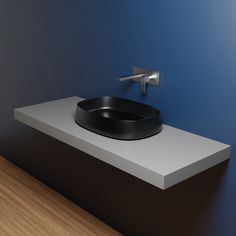 a black bowl sitting on top of a white counter next to a faucet