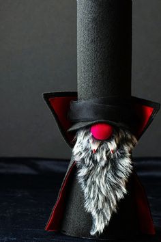 a black top hat with a red nose and beard