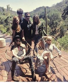 a group of people sitting on top of a wooden deck