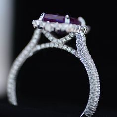 a diamond and amethyst ring is shown in this close up photo with black background