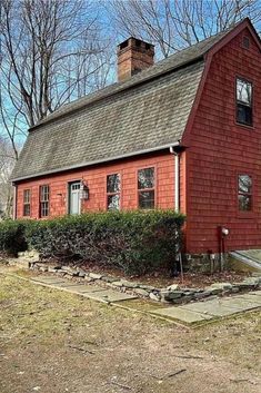 an old red house with a chimney on the roof