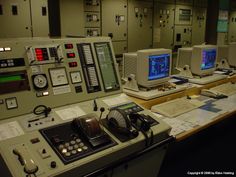 the control room is full of many electronic devices, including two monitors and several other equipment