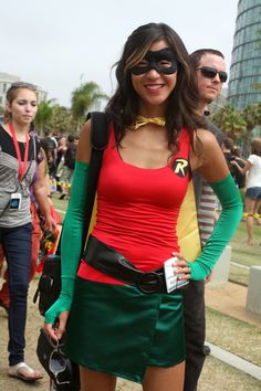 a woman dressed in costume poses for the camera at an outdoor event with other people