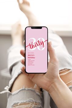 a woman holding up her phone with the word thirty on it in front of her