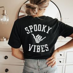 Spooky Vibes Halloween Shirt, Vintage Skeleton Halloween Tee, Halloween Shirts with Back Print, Spooky Witch tshirt, Womens Halloween Party Top, Funny Halloween Gift At this time, we do not offer gift messaging, wrapping or notes, please send a separate card to your recipient if you are directly shipping a package. PLEASE NOTE Choose your t-shirt's color and size on the drop-down menu to the right. You can scroll through the photos to see the size chart and color swatches. For an oversized look, Diy Halloween Shirts, Witch Tshirt, Halloween Mode, Halloween Shirt Design, Halloween Tee Shirts, Boho Halloween, Spooky Witch, Vintage Skeleton, Cute Shirt Designs