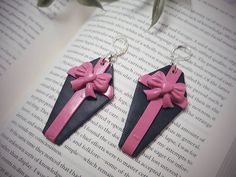 "🖤 These beautiful pink and black polymer clay coffin Bow earrings are the perfect spooky accessory for Valentines Day! A great gift for friends, sisters, teenage girls or even yourself! 🖤 All designs are original and handmade from polymer clay and resin! Hung elegantly from nickel free, hypoallergenic lever back earrings! 🖤 Earring Specs: Length 3\" Width 1.25\" 🖤 As with all clay products, we recommend keeping any clay jewelry away from water and if a safe dry place when not in use. This w Clay Coffin, Pastel Goth Earrings, Coffin Earrings, Coffin Jewelry, Spooky Earrings, Clay Products, Earrings Goth, Black Polymer Clay, Gothic Christmas