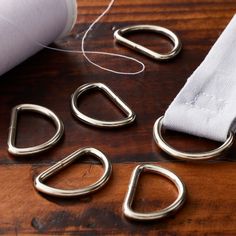 four pieces of silver metal sitting on top of a wooden table next to a white piece of cloth