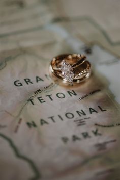 two wedding rings sitting on top of a map