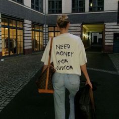 a woman with a t - shirt that says need money for custom on her back