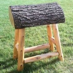 a wooden stool made out of logs in the grass