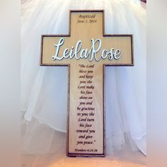 a wooden cross with the words leila rose written on it