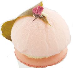 a pink frosted cupcake with a flower on it's top is shown in front of a white background