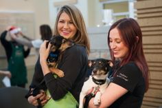 two women holding small dogs in their arms