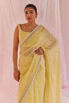 Yellow saree in silk chanderi base and with dori embroidery, sequin and pearl embellishments. Paired with a matching padded square neck silk chanderi sleeveless blouse.
Components: 2
Pattern: Embroidered
Type Of Work: Pearl, Sequin
Neckline: Square
Sleeve Type: Sleeveless
Fabric: Silk Chanderi, Lining: Shantoon
Color: Yellow
Other Details: 
Model Height: 5ft 6inches, wearing size M
Occasion: Puja, Mehendi and Haldi - Aza Fashions Festive Bollywood Pre-draped Saree In Chanderi, Summer Lehenga With Resham Embroidery In Traditional Drape, Traditional Drape Lehenga With Resham Embroidery For Summer, Summer Semi-stitched Pre-draped Saree For Designer Wear, Summer Designer Chanderi Saree, Summer Choli With Resham Embroidery In Traditional Drape, Traditional Silk Pre-draped Saree For Summer, Summer Chanderi Saree With Dupatta, Chanderi Saree With Dupatta For Summer