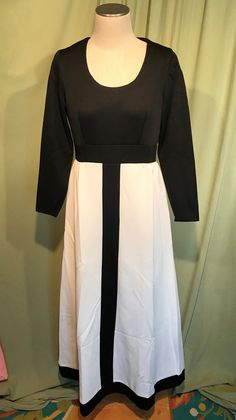 "This is a cute vintage dress from the 70's. No labels or tags. The bust measures 36\", waist 30\", see measurements below. Made of a black & white polyester. The dress is maxi length & it is not lined. It has long sleeves with small vents in the cuff edge seams. The top half & center stripe on the skirt are plain black & the skirt is plain white. Neckline is a scoop neck. Zips in the back with a nylon zipper. The dress is in very good condition, no wear or tear. No soil or stain Black Retro Maxi Dress For Spring, White A-line Vintage Dress For Evening, White A-line Evening Vintage Dress, Black Retro Maxi Dress, White Vintage Midi Dress For Evening, Vintage White Evening Midi Dress, White Retro Midi Dress For Party, Black Retro Midi Vintage Dress, Retro Black Maxi Dress