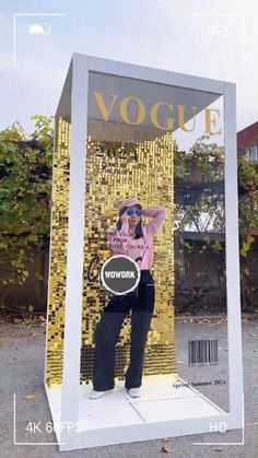 a woman standing in front of a gold mosaic wall with her hands on her hips