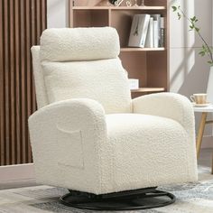 a white recliner chair sitting on top of a wooden floor next to a book shelf