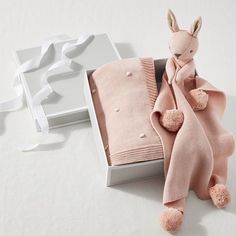 a baby's gift box with a pink bunny sweater and blanket