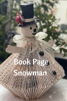 a book page snowman is sitting on top of a table