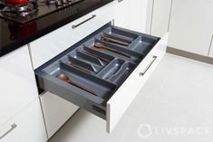 an open drawer in a kitchen with utensils and spoons on the drawers