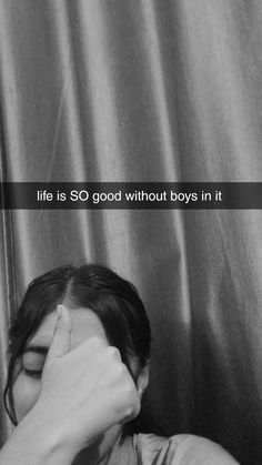 a woman covering her face with her hand next to a curtain that says life is so good without boys in it