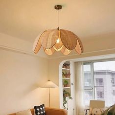 a living room filled with furniture and a light fixture hanging from the ceiling above it