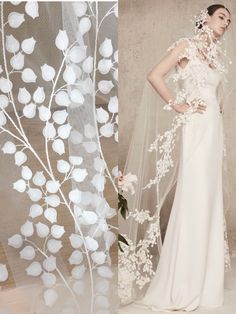 a woman wearing a wedding dress and veil with flowers on the side, standing in front of a backdrop