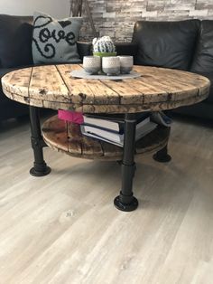 a coffee table made out of an old barrel and some books on the bottom shelf