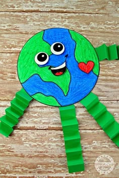 a paper plate with the earth on it and some green sticks sticking out of it